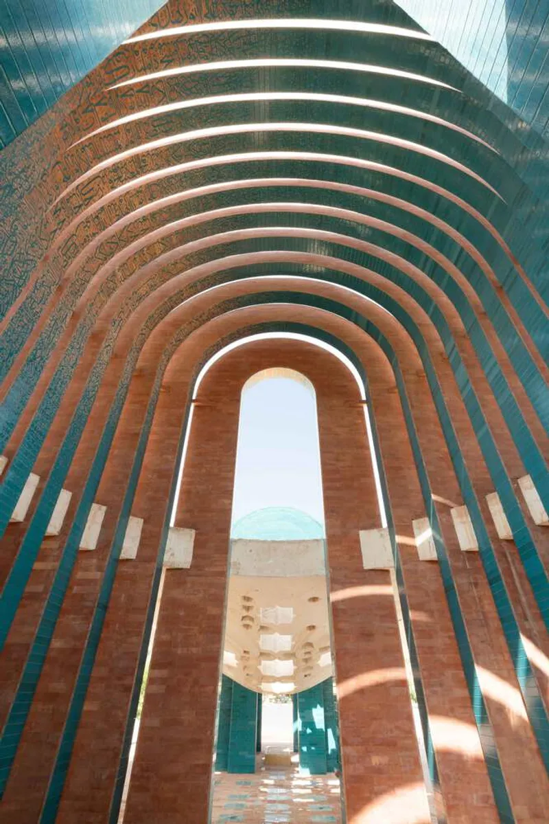 Interior view looking up through the alternating terracotta and teal ribbed vault toward an arched opening