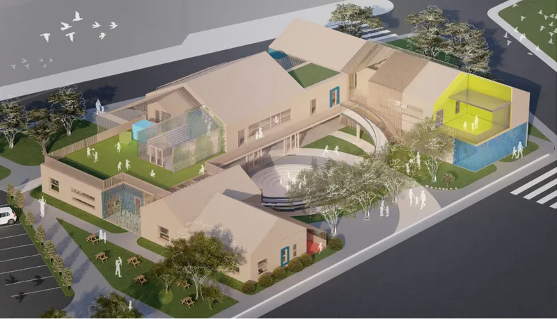 Oblique aerial view showing the massing with green roofs, courtyard bridges, and a yellow-lit cubic volume