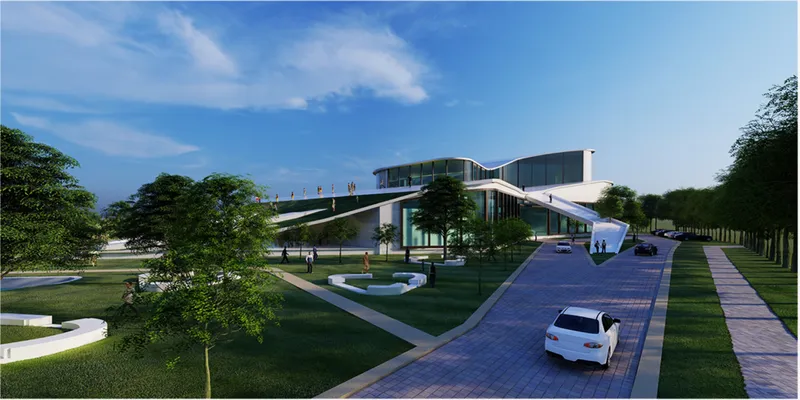 Approach view showing the curving roof canopy, glass facade, and entry drive through manicured parkland