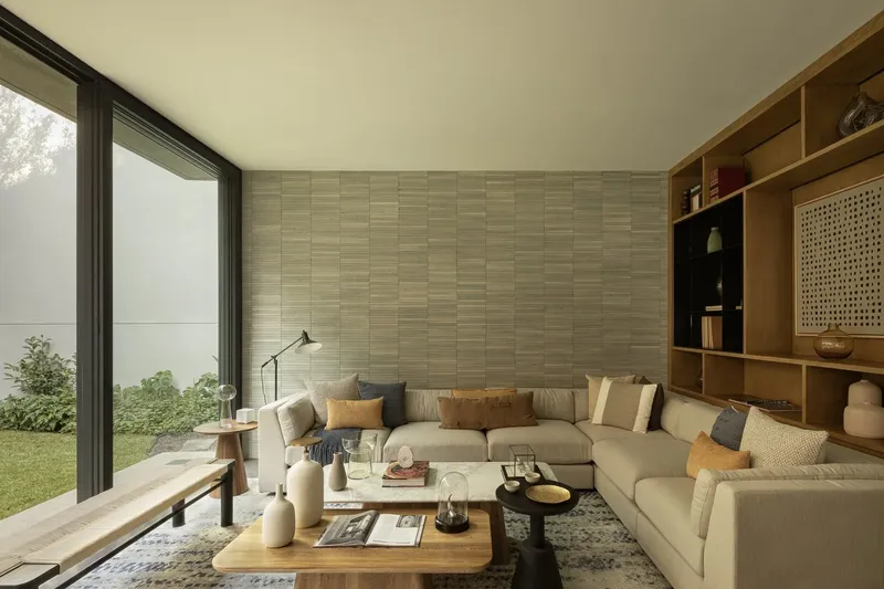 Living room with horizontal timber-clad wall and floor-to-ceiling glass opening to lawn