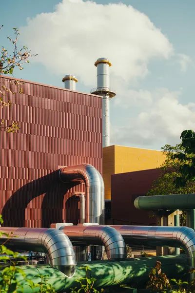This architectural image showcases a modern industrial building with a striking facade composed of v