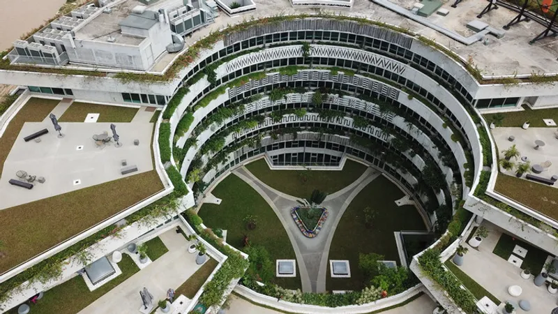 Aerial view of the circular building showing concentric planted balconies wrapping around the central courtyard space