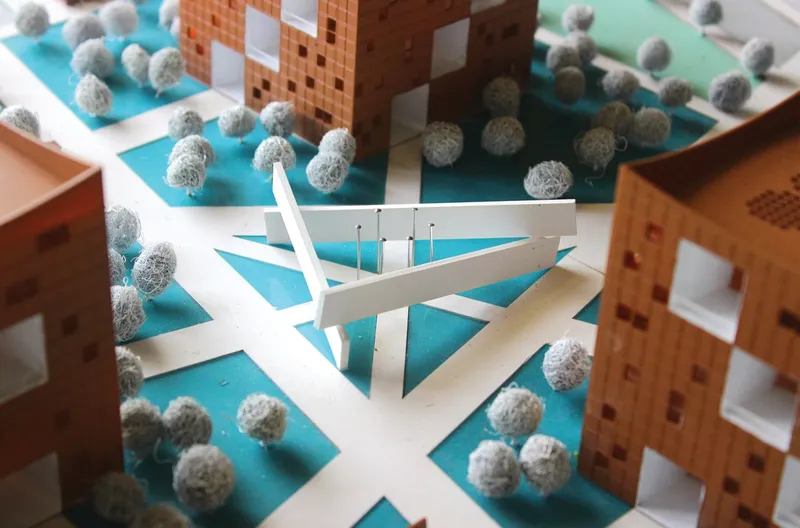 Close-up of white folded memorial structure within the model plaza surrounded by blue ground plane and textured trees