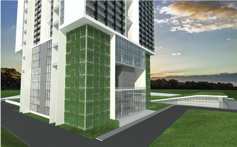 Corner view of the tower base with vertical green wall panels beside glazed volumes at sunset