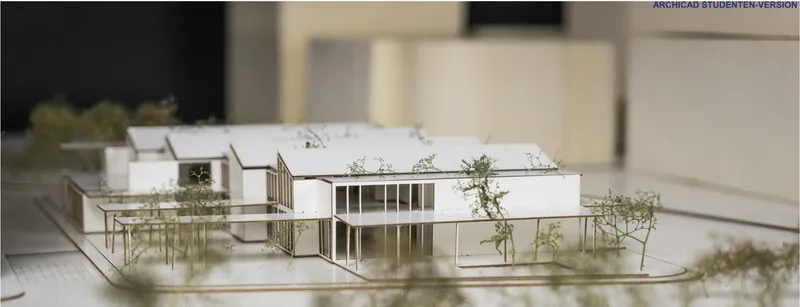 Physical model showing flat-roofed volumes with glazed facades and miniature trees on the site
