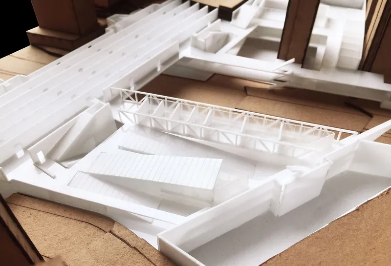 Close-up of physical model showing the triangular truss roof structure over a recessed courtyard volume