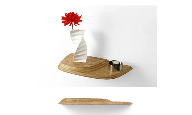 Small laminated wood shelf with a red flower in a spiral vase and a metal tea light