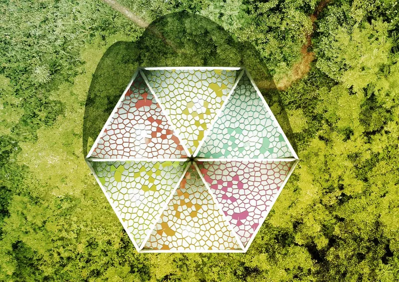 Drone view of a single hexagonal pavilion with cellular colored panels surrounded by greenery