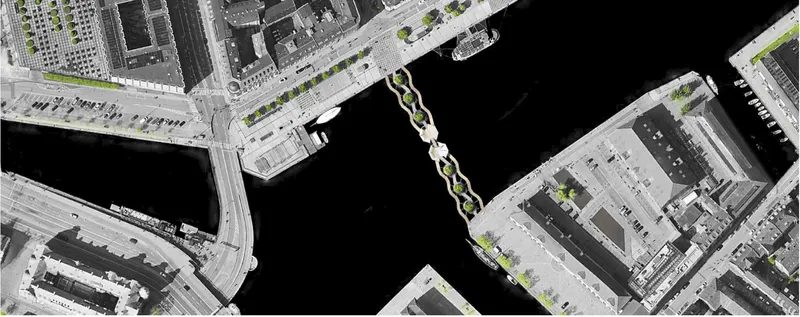 Aerial site plan showing a linear bridge crossing dark water between urban blocks and parking lots