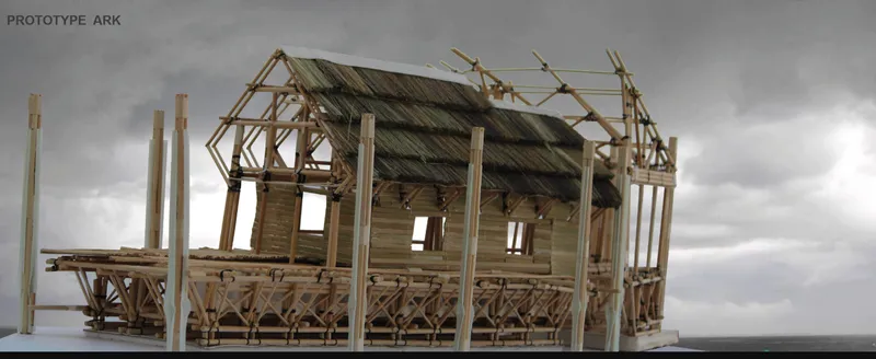 Physical model of a timber-framed shelter with exposed joinery and partial roof under an overcast sky
