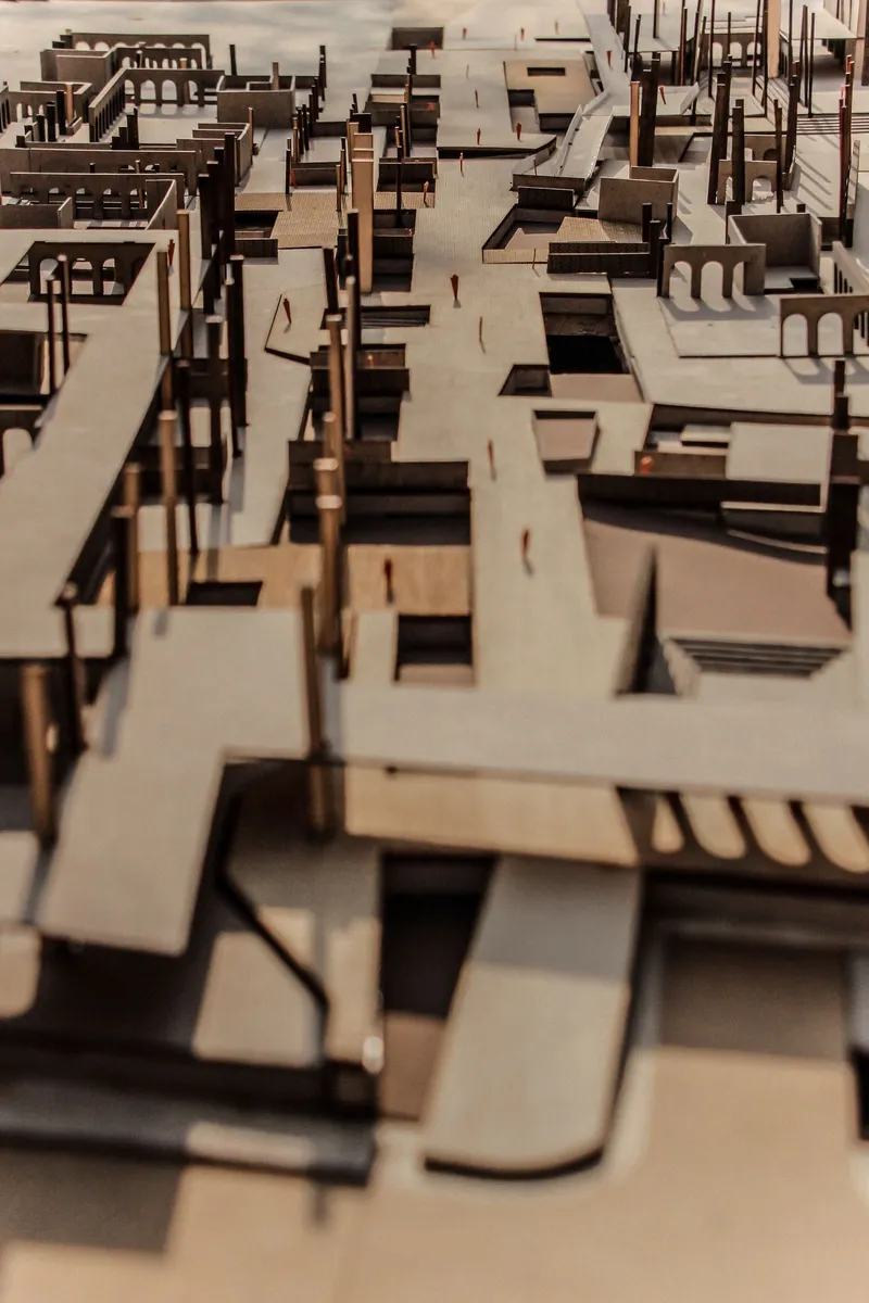 Physical model in cardboard showing a dense cluster of buildings with varied rooflines and openings