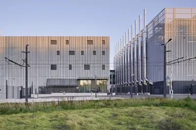 This architectural image showcases a modern industrial building with a striking metal facade and a s