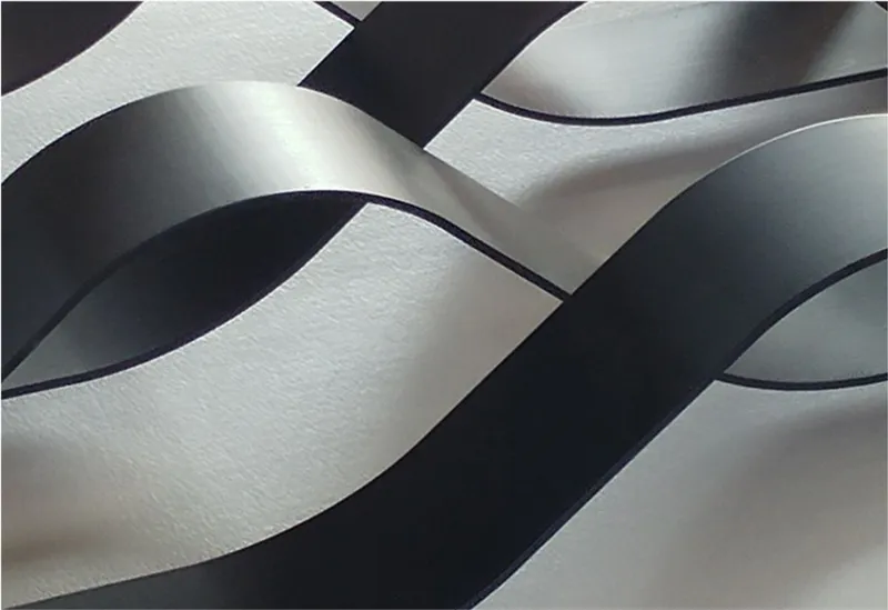 Close-up detail of the bent metal strips, revealing the fluid wave geometry inspired by ocean currents.