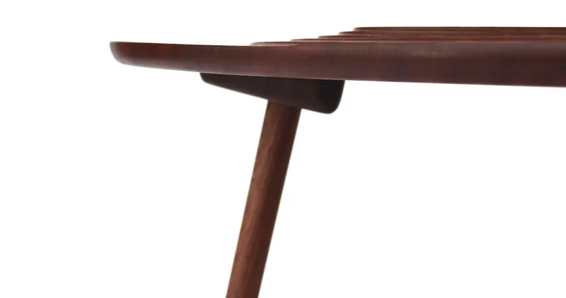 Precision-crafted wooden legs supporting a fluid, contoured surface.