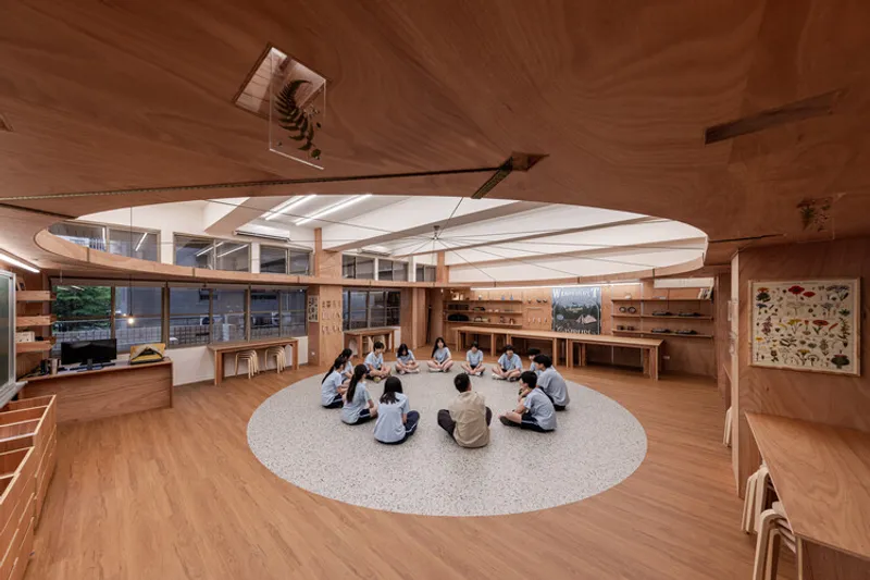 Circular learning space with plywood surfaces, terrazzo floor and students gathered in center