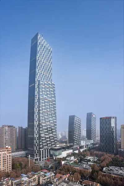 This architectural image showcases a modern skyscraper with a distinctive geometric pattern on its g