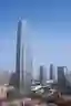 This architectural image showcases a modern skyscraper with a distinctive geometric pattern on its g