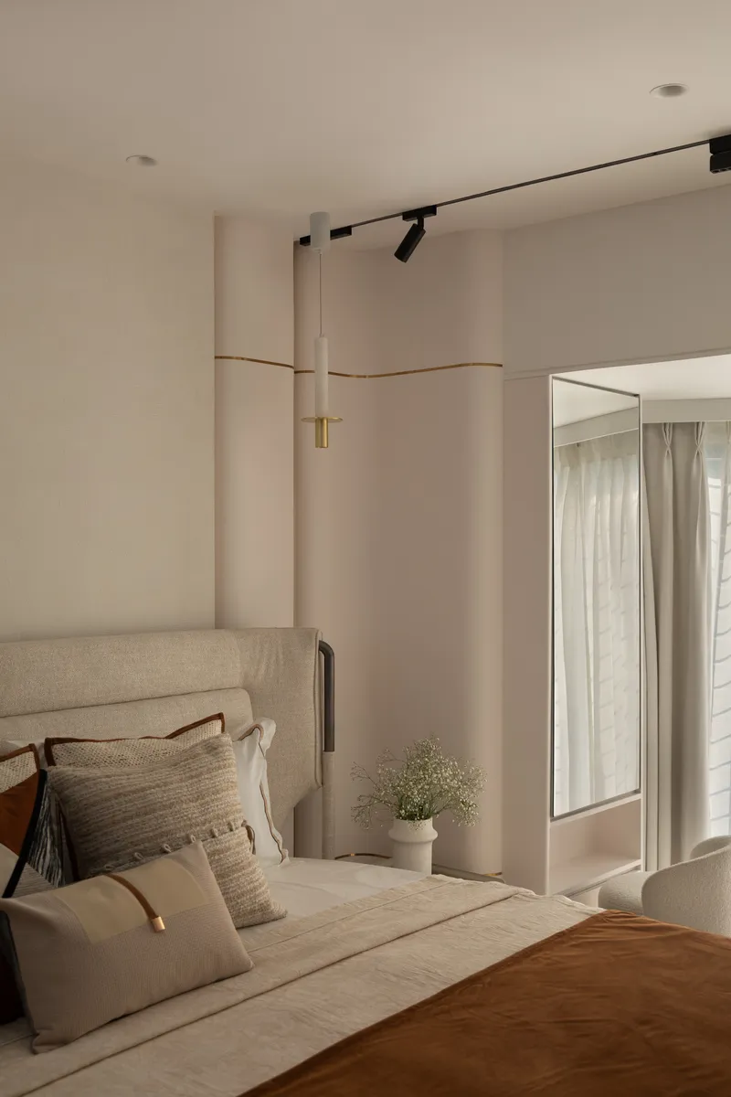 A bedroom with a slim brass-and-stone band running horizontally across the wall.