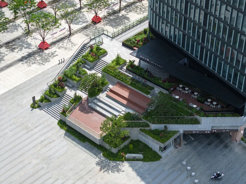 Aerial view of the terraced sunken plaza with planted beds and zebra-striped crosswalks