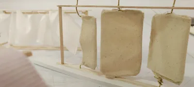 This image showcases an architectural model exploring the use of fabric within a wooden frame. The m