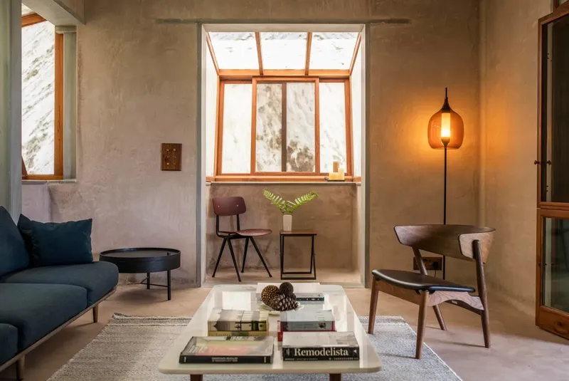 A villa living room starring a chair by Sibast, a sofa by &Tradition, a side table by Menu, and a custom coffee table by Viewport Studio. 