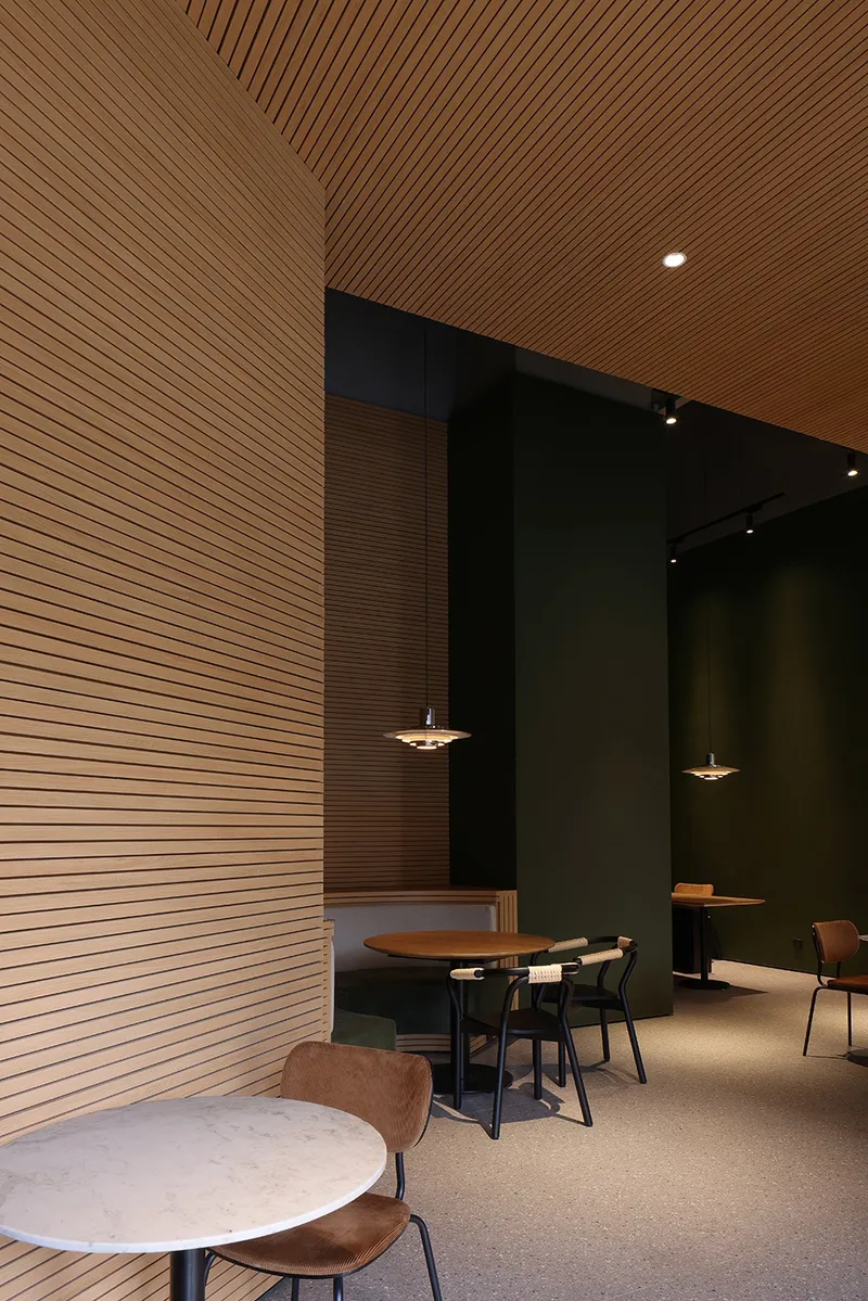 The warm wood colour with the brand's unique dark green is the keynote of the space © Xiao Le