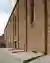 This architectural image showcases a brick building facade with a series of arched openings and a pr