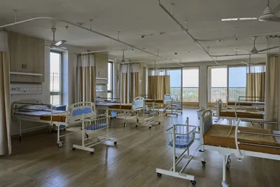 This architectural image showcases a modern hospital room featuring multiple patient beds and baby b