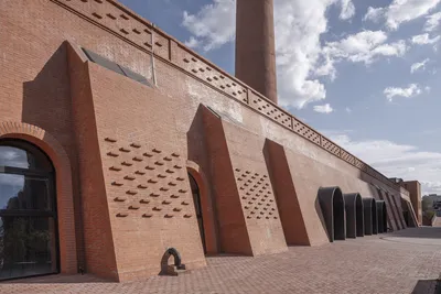 This architectural image showcases a brick building with a striking facade. The design incorporates 