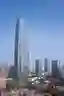 This architectural image showcases a modern skyscraper with a striking glass facade and geometric pa