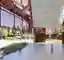 This architectural image showcases a modern pavilion structure within a park setting. The design fea