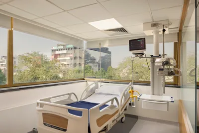 This architectural image showcases a modern hospital room featuring a patient bed with medical equip