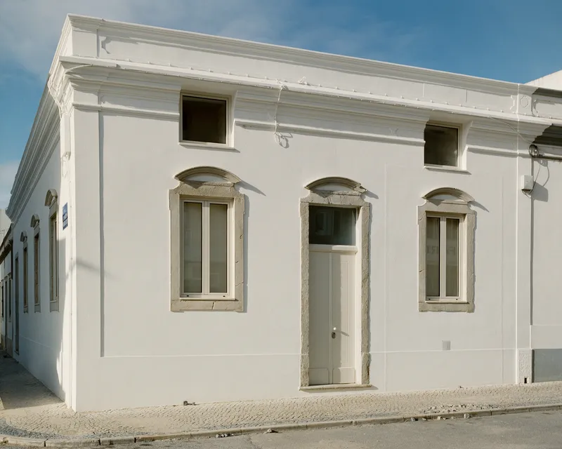 Frontal view of the long facade with the original symmetrical openings and stone surrounds