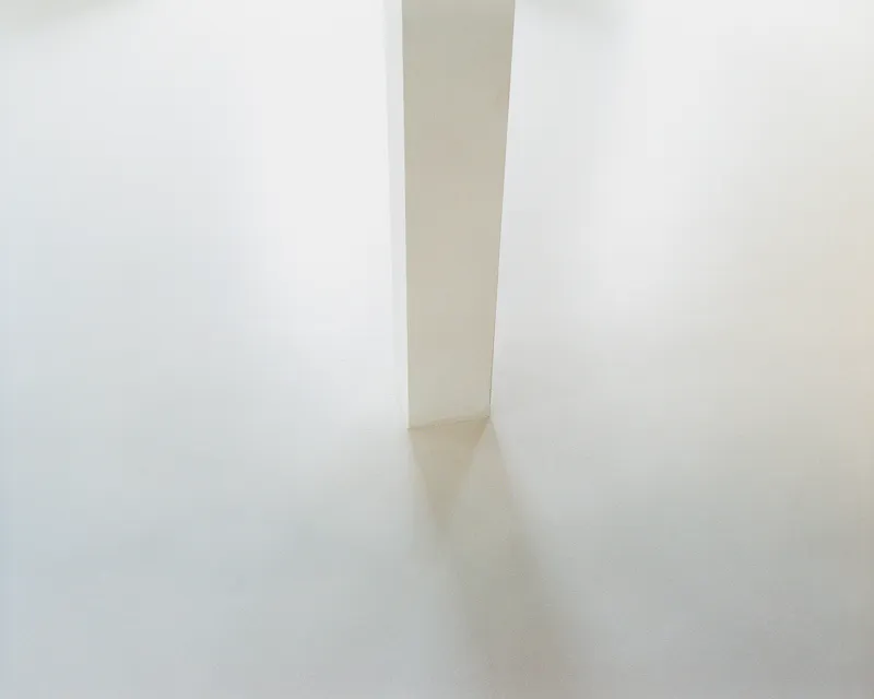 Detail of the slim white pillar standing on the polished concrete floor