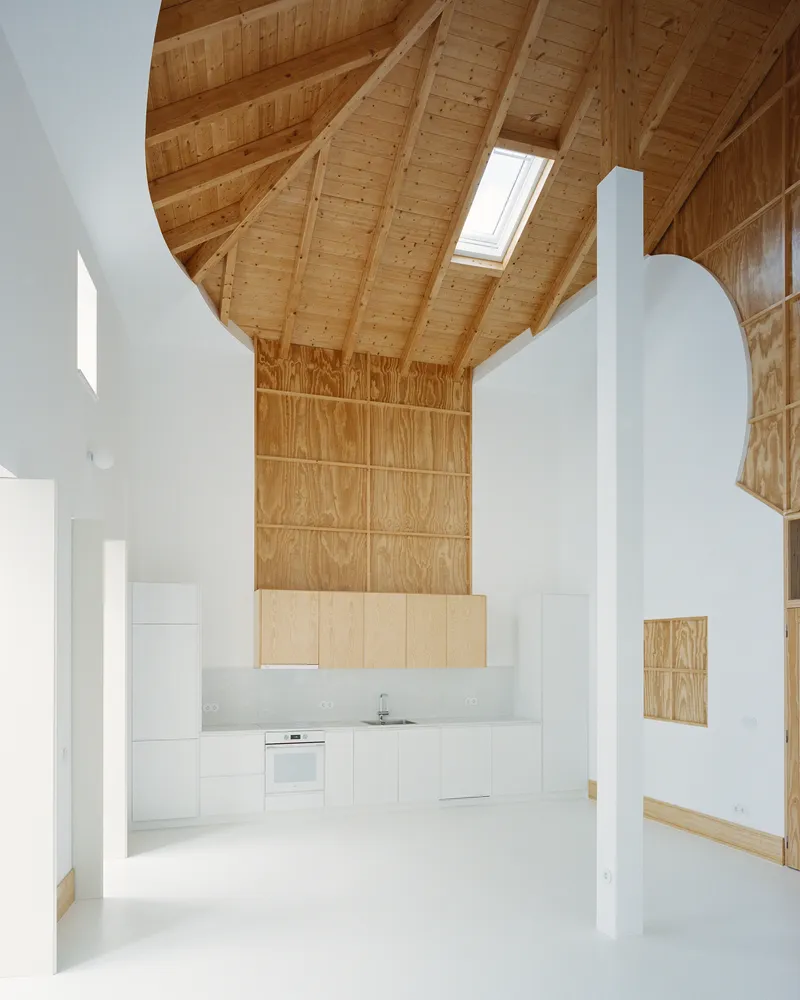 Frontal view of the kitchen with the plywood chimney panel and the curved roof above